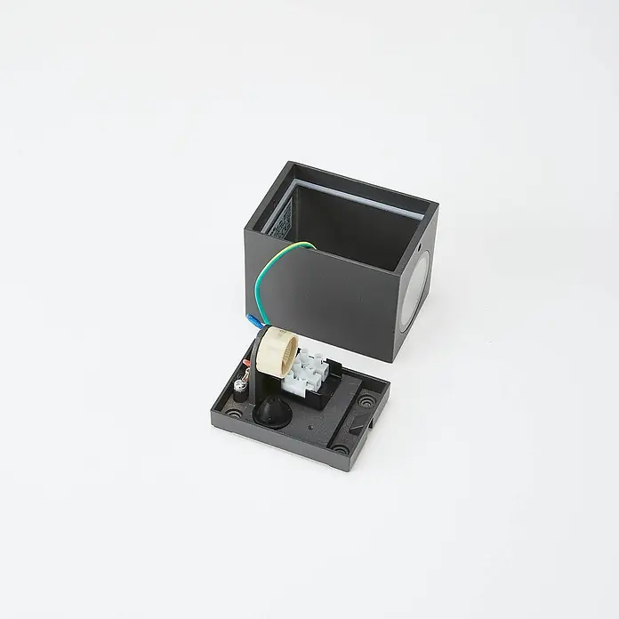 Lucande Außenwandleuchte Xava - schwarz, schwarz, IP65 - Zerlegte dunkelgraue Außenwandleuchte mit sichtbarer Innenverdrahtung, Lampenfassung und Klemmenblock.