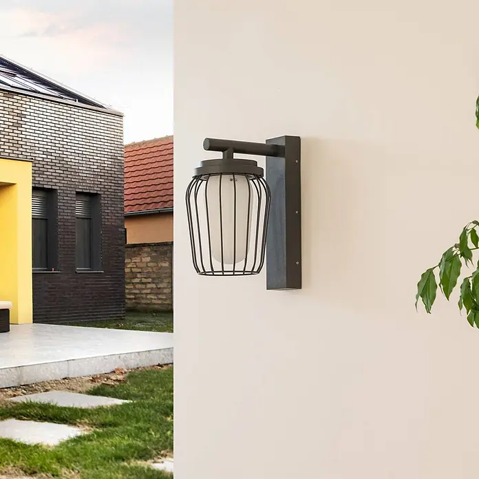 Lucande Außenwandleuchte Chandan - schwarz, schwarz, IP54 - Schwarze Metall-Außenwandleuchte mit weißem Diffusor, an heller Wand neben einem modernen Haus montiert.