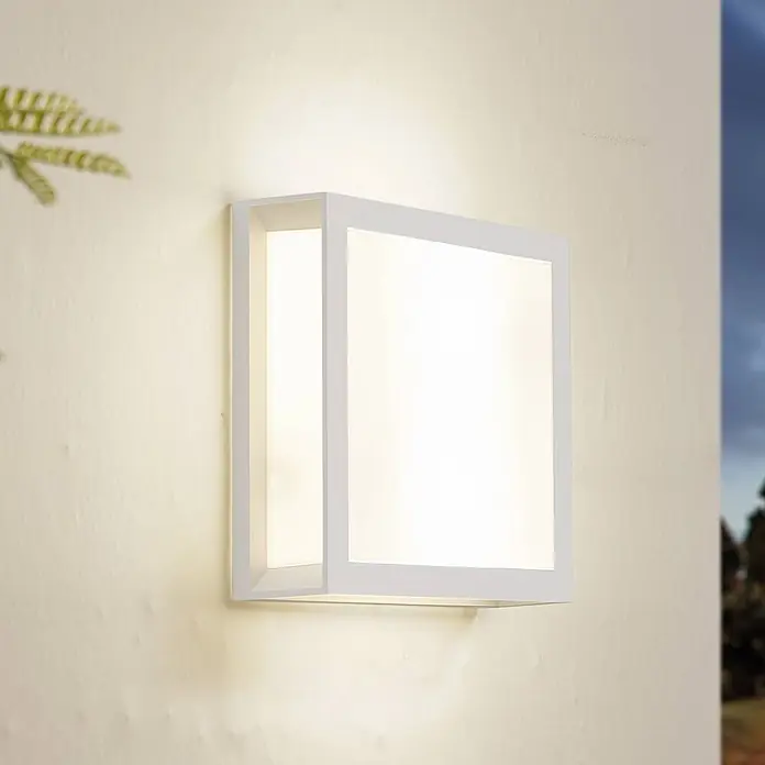Lindby Außenwandleuchte Sivana - weiß / opal, weiß / opal, IP44 - Weiße quadratische Außenwandleuchte an beiger Wand, die warmes Licht abstrahlt.