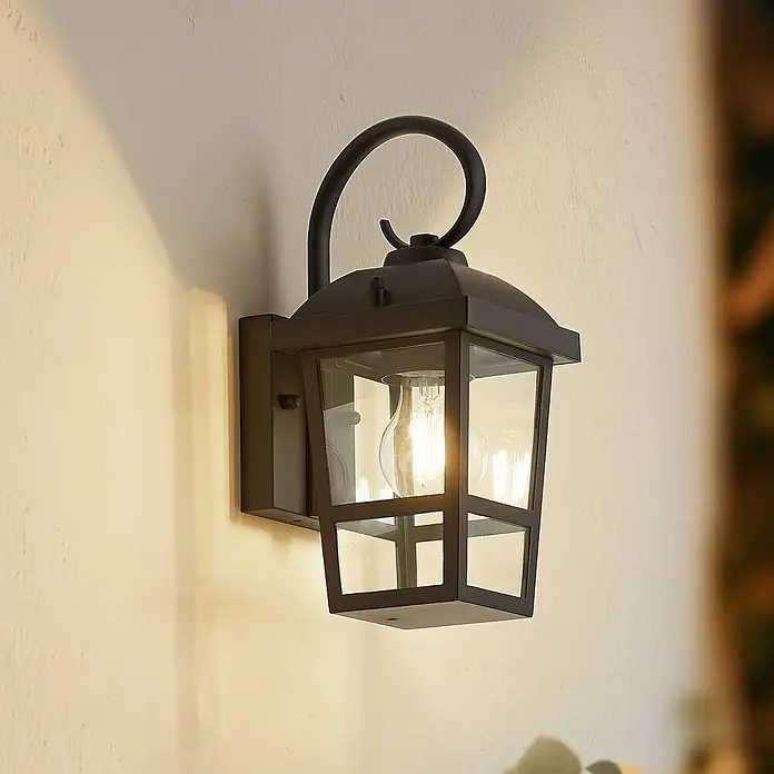 Lindby Außenwandleuchte Eloane - 16 x 13 x 29 cm, schwarz, schwarz, IP44 - Schwarze Metall-Wandlaterne für den Außenbereich mit Klarglas und beleuchteter Edison-Birne, wirft warmes Licht an eine Wand.