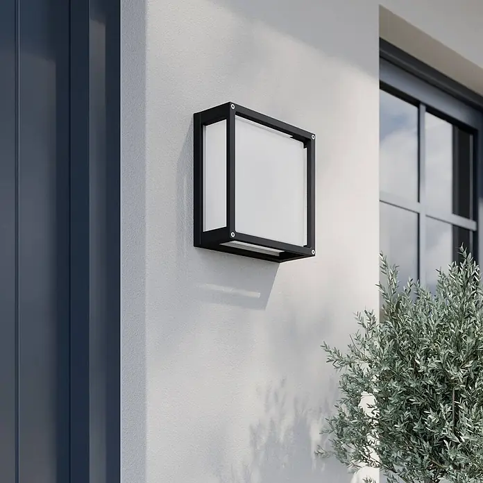 Lucande Außenwandleuchte Aurelien - schwarz, IP54 - Quadratische schwarze Außenwandleuchte mit weißem Diffusor, an der Hauswand montiert.
