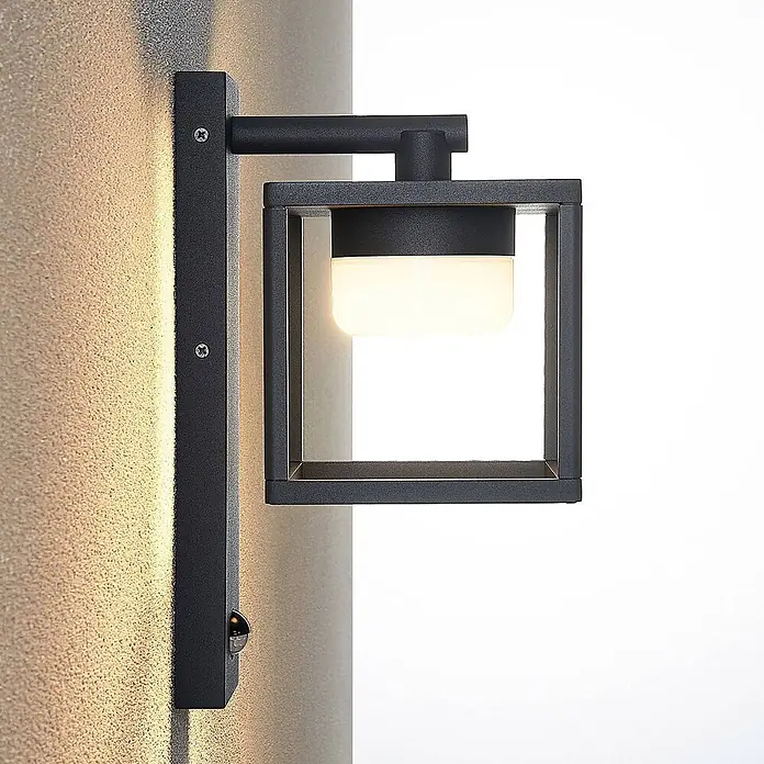 Lucande Außenwandleuchte Timio - alu / grau / zink, alu / grau / zink, IP44 - Schwarze Metall-Außenwandleuchte mit weißem Diffusor, die eine strukturierte Wand beleuchtet. Mit Bewegungssensor.