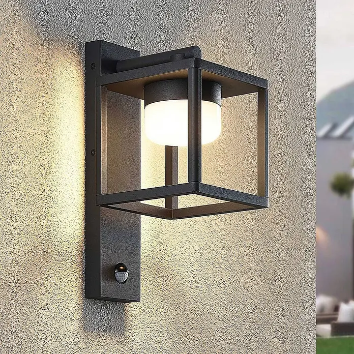 Lucande Außenwandleuchte Timio - alu / grau / zink, alu / grau / zink, IP44 - Schwarze Außenwandleuchte mit quadratischem Rahmen und Bewegungssensor, beleuchtet eine strukturierte Wand.