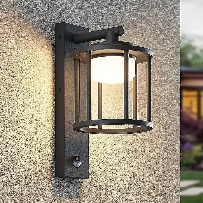 Lucande Außenwandleuchte Berenike - alu / grau / zink, alu / grau / zink, IP44 - Dunkle Metall-Außenwandleuchte mit weißem Diffusor und Bewegungssensor an strukturierter Wand zur Gartenbeleuchtung.