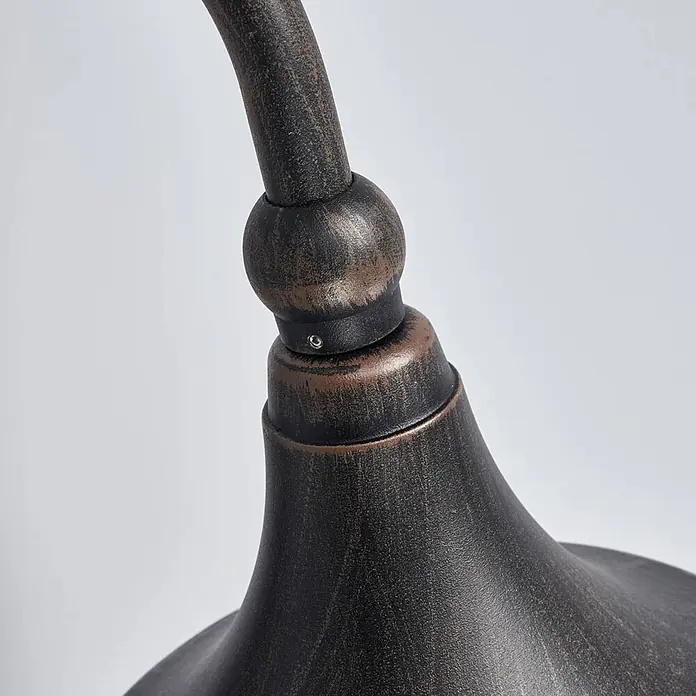 Lindby Außenwandleuchte Daphne - schwarz, schwarz, IP44 - Nahaufnahme eines Gelenks einer dunklen Bronze-Außenleuchte. Ein gebogener Arm trifft auf einen glockenförmigen Schirm.