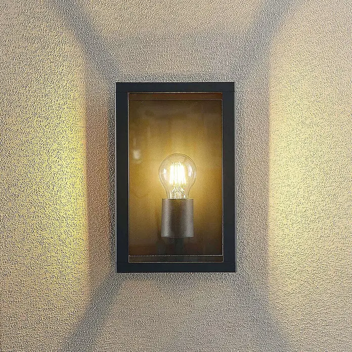 Lindby Außenwandleuchte Giavanna - 17,1 x 18 x 28 cm, schwarz, schwarz, IP44 - Dunkelgraue rechteckige Außenwandleuchte mit sichtbarer warmweißer Vintage-LED-Birne, die Licht auf eine strukturierte Wand wirft.