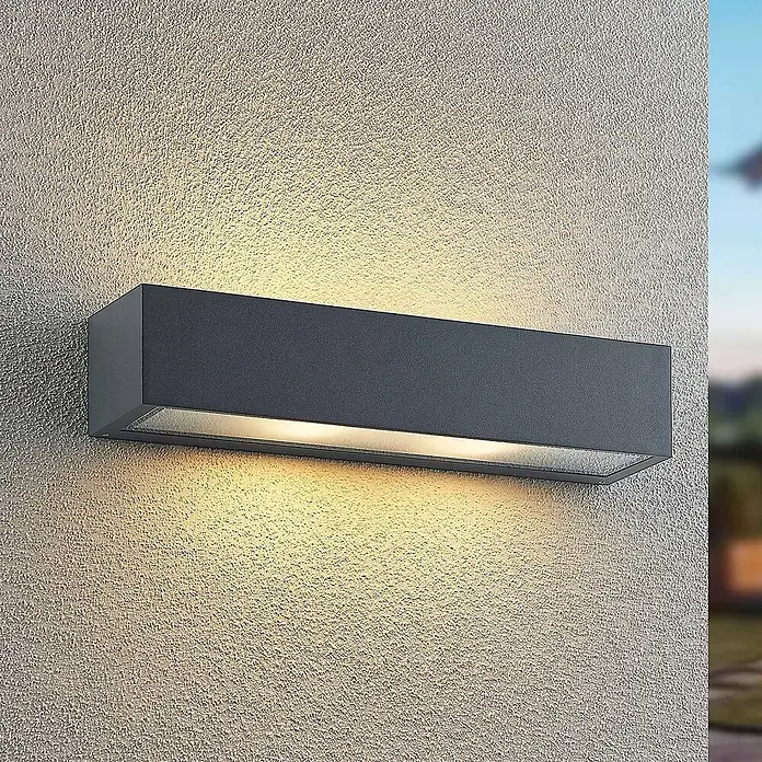 Arcchio Außenwandleuchte LengoE27 - alu / grau / zink, IP54 - Anthrazitfarbene, rechteckige Außenwandleuchte, die warmes Licht auf eine strukturierte Wand wirft.