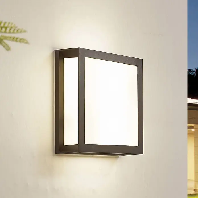 Lindby Außenwandleuchte Sivana - schwarz, schwarz, IP44 - Moderne dunkelgraue quadratische Außenwandleuchte mit zwei Leuchtflächen, an heller Gebäudefassade montiert.