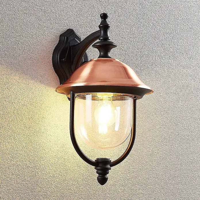 Lindby Außenwandleuchte Clint - kupfer, IP44 - Wandmontierte Außenleuchte mit schwarzem Metallrahmen, kupferfarbener Kuppel und klarem Glasdiffusor mit Glühbirne.