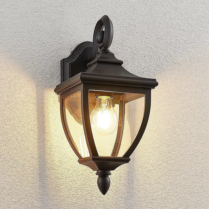 Lindby Außenwandleuchte Cerys - 19,5 x 16,5 x 37,2 cm, schwarz, IP44 - Dunkelbronzene Außenwandlaterne mit Klarglas und beleuchteter Glühbirne, an einer strukturierten Wand montiert.