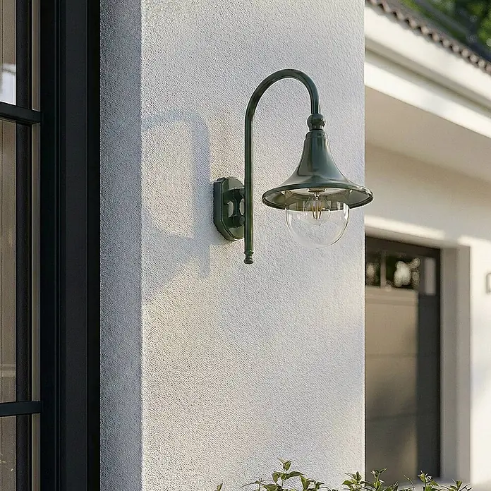 Lindby Außenwandleuchte Daphne - 35,5 x 24,5 x 44,2 cm, grün, grün, IP44 - Grüne Metall-Außenwandleuchte mit klarer Glaskugel, an einer strukturierten weißen Gebäudewand montiert.