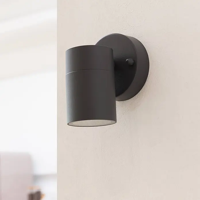 Prios Außenwandleuchte Tulimar - schwarz, schwarz, IP44 - Mattschwarze zylindrische Wandleuchte an einer Wand montiert.