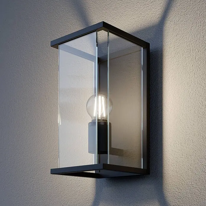 Lucande Außenwandleuchte Annalea - schwarz, klar / transparent, IP54 - Moderne Wandleuchte aus schwarzem Metall und Klarglas mit beleuchteter LED-Birne, an einer Wand montiert.