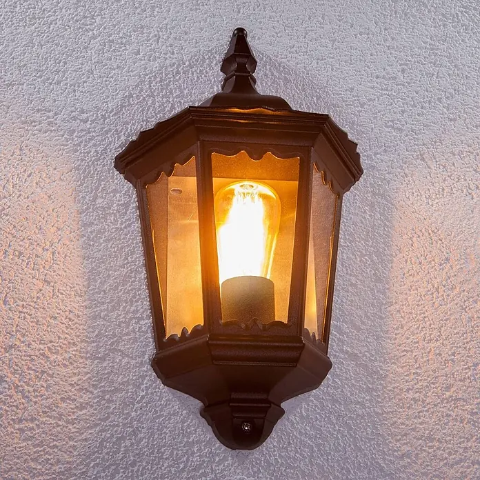 Lindby Wandleuchte aussen in schwarz, transparent, Aussenlampe Wand -  - Dunkelbraune sechseckige Wandlaterne mit klaren Scheiben, beherbergt eine beleuchtete Edison-Glühbirne.