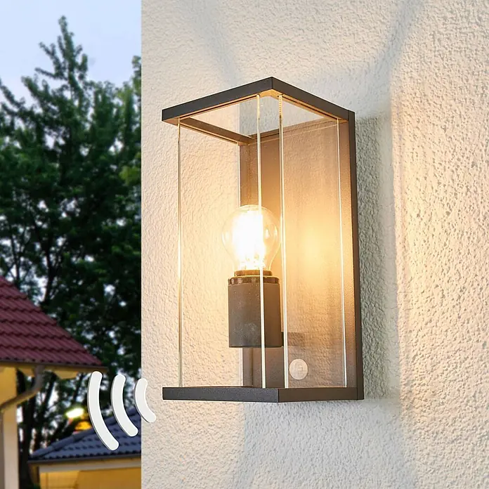 Lucande Außenwandleuchte Annalea - schwarz, klar / transparent, IP54 - Schwarze Außenwandleuchte mit klaren Scheiben, sichtbarer Glühbirne und Bewegungssensor an strukturierter Wand.