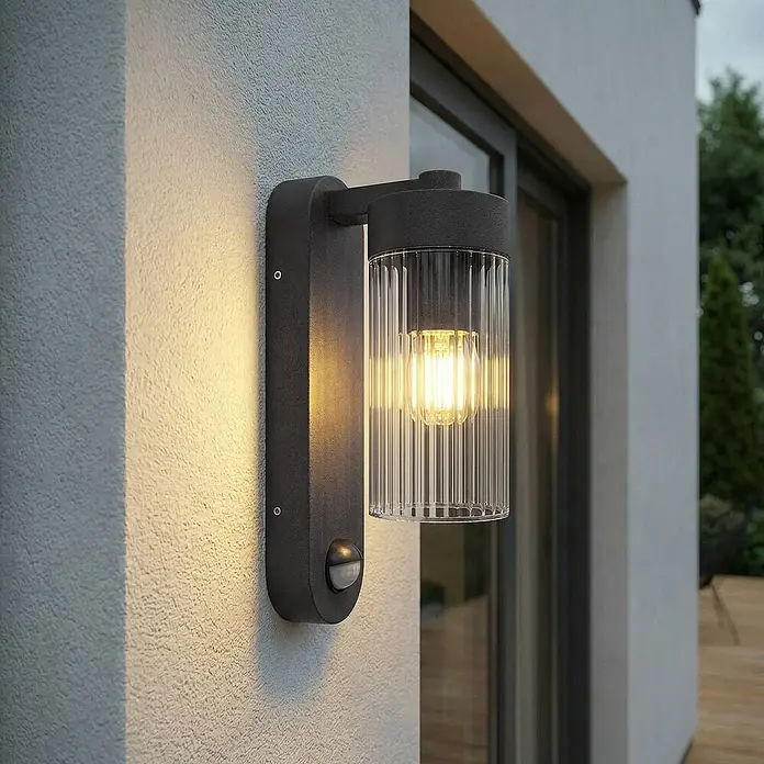 Lindby Außenwandleuchte Kaliro - 13,8 x 8 x 23,4 cm, schwarz, klar / transparent, IP54 - Dunkelgraue Außenwandleuchte mit klarem Riffelglas, warmem Leuchtmittel und Bewegungssensor.
