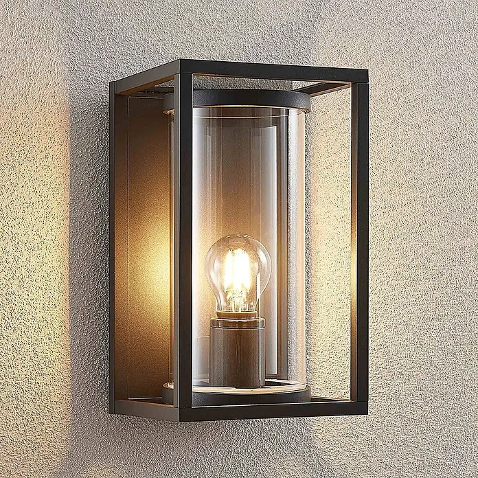 Lucande Außenwandleuchte Brienne - alu / grau / zink, IP54 - Moderne schwarze, rechteckige Außenwandleuchte mit Klarglas und beleuchteter Glühbirne an einer strukturierten Wand.