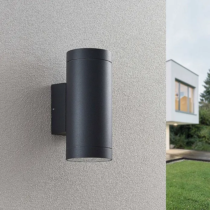Lucande Außenwandleuchte Thomke - alu / grau / zink, alu / grau / zink, IP65 - Schwarze zylindrische LED-Außenwandleuchte als Up-and-Down-Strahler an einer strukturierten Hauswand.