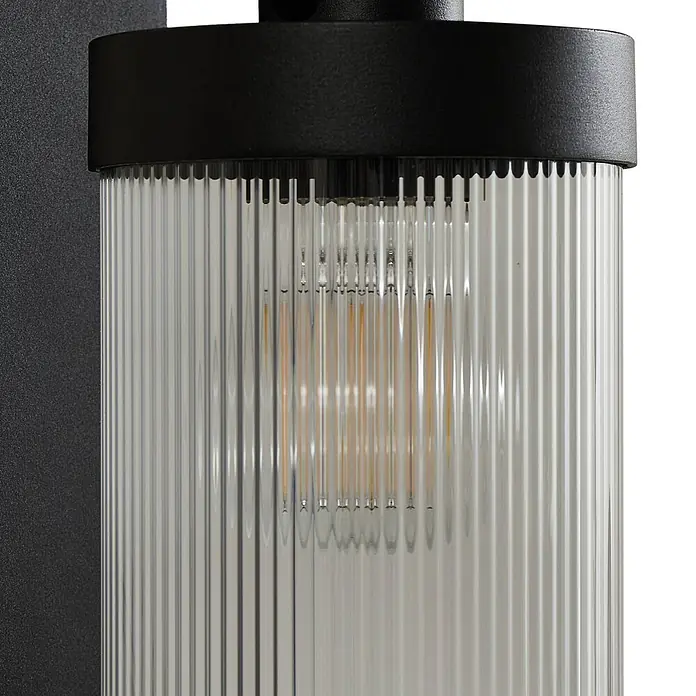 Lindby Außenwandleuchte Yrene - schwarz, schwarz, IP44 - Schwarze Wandleuchte mit geriffeltem Klarglaszylinder und sichtbarer LED-Glühbirne.