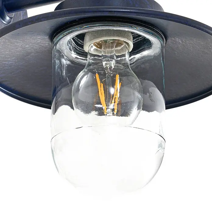 Lindby Außenwandleuchte Eloretta - schwarz, schwarz, IP44 - Nahaufnahme einer blauen Wandleuchte aus patiniertem Metall mit Klarglas und LED-Glühfadenlampe.