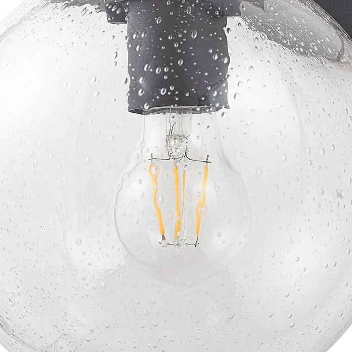 Lindby Außenwandleuchte Dangan - 26,1 x 20 x 28,8 cm, klar / transparent, IP44 - Leuchte mit gesätem Glaskugel, LED-Filamentbirne und dunkelgrauer Halterung.