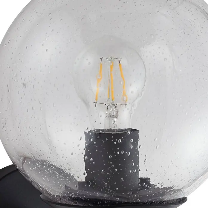 Lindby Außenwandleuchte Dangan - 26,1 x 20 x 28,8 cm, klar / transparent, IP44 - Klarglas-Kugel-Leuchte mit Samenstruktur, schwarzem Sockel und sichtbarer LED-Glühbirne.