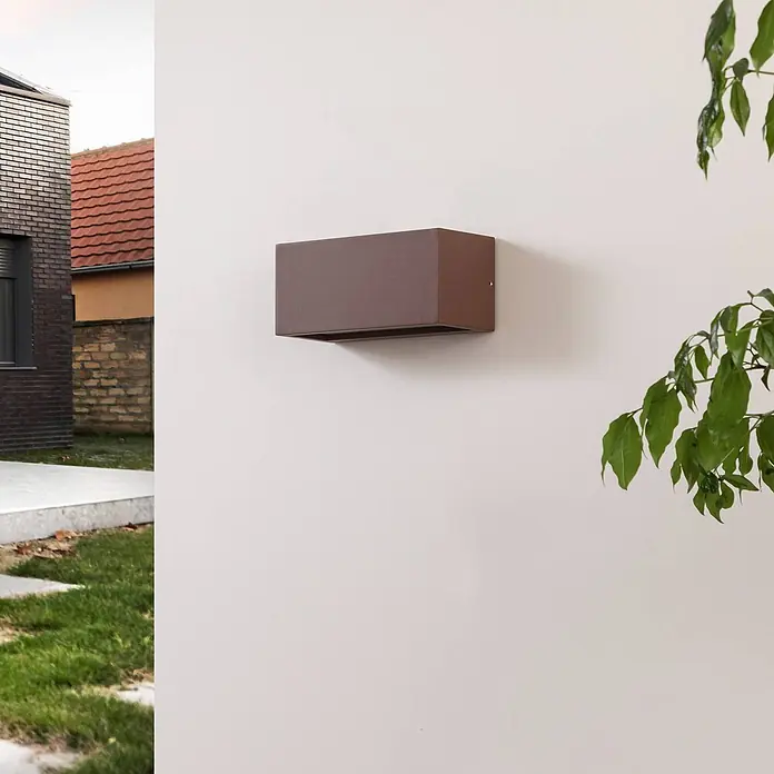 Lucande Außenwandleuchte Bente - braun / rost, braun / rost, IP54 - Dunkelbraune rechteckige Außenwandleuchte, neben Gebäude und Grünpflanze.