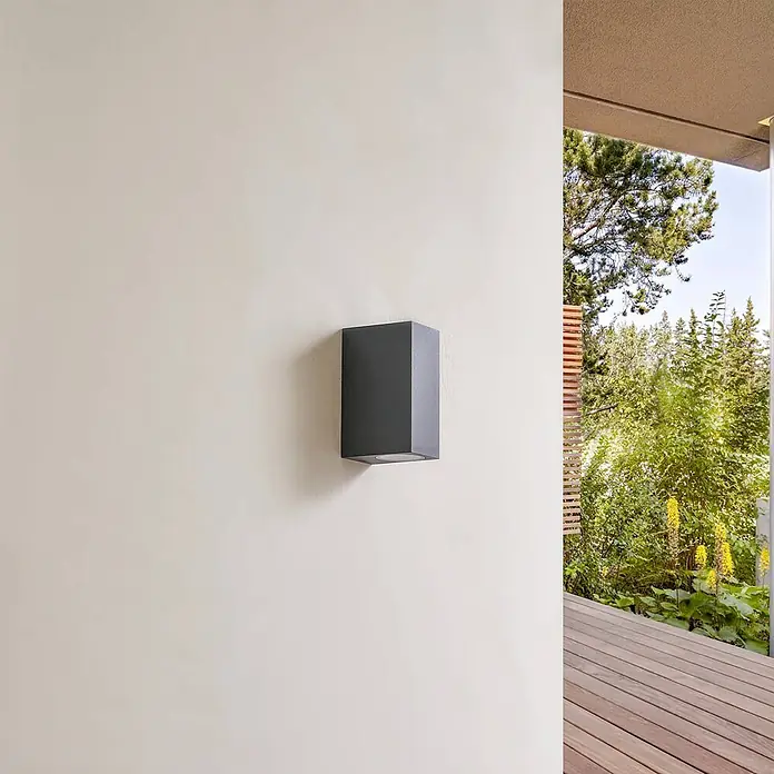 Lindby Außenwandleuchte Fijona - 9 x 6,5 x 15 cm, grün, IP44 - Dunkelgraue rechteckige Außenwandleuchte, ein Up- & Downlight, an einer hellen Wand montiert.