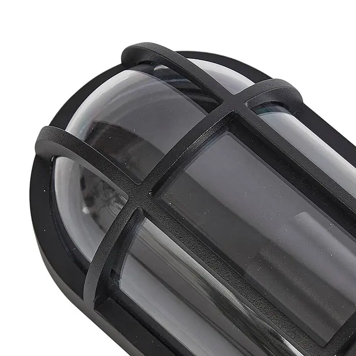 Lucande Außenwandleuchte Serine - schwarz, klar / transparent, IP65 - Nahaufnahme einer schwarzen, ovalen Außenwandleuchte mit Schutzgitter und klarer, gewölbter Abdeckung.