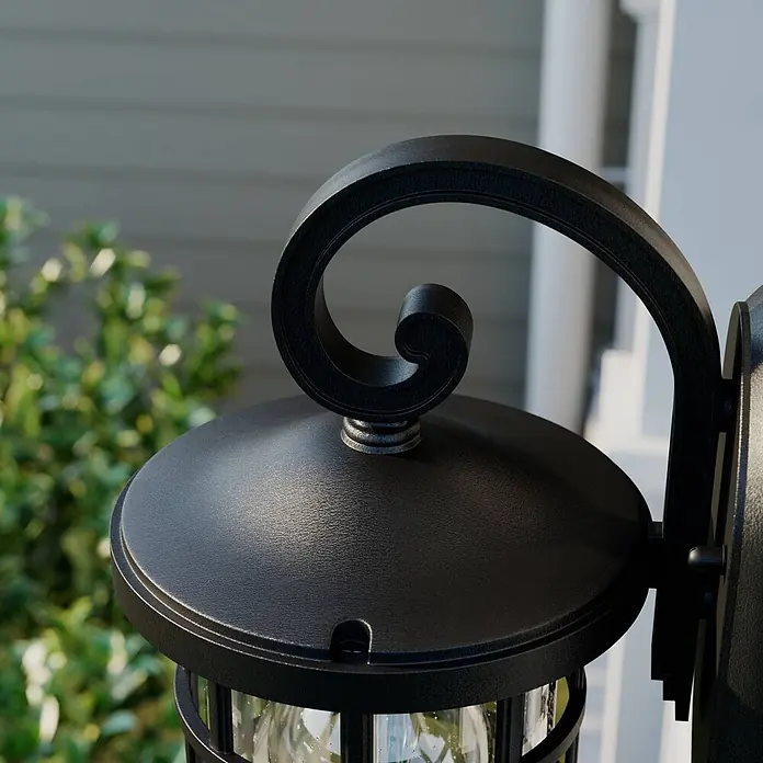 Lindby Außenwandleuchte Ankea - 19,4 x 15,2 x 28 cm, schwarz, IP23 - Schwarze strukturierte Wandlaterne aus Metall mit dekorativem Schnörkelarm, installiert.