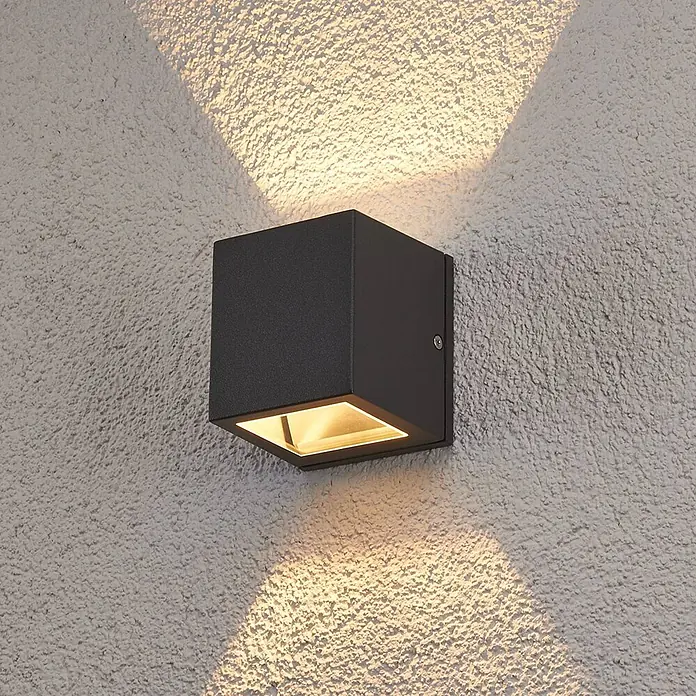 Lucande Außenwandleuchte Maurice - schwarz, schwarz, IP54 - Schwarze quadratische Außenwandleuchte an strukturierter Wand, wirft warmes Licht nach oben und unten.