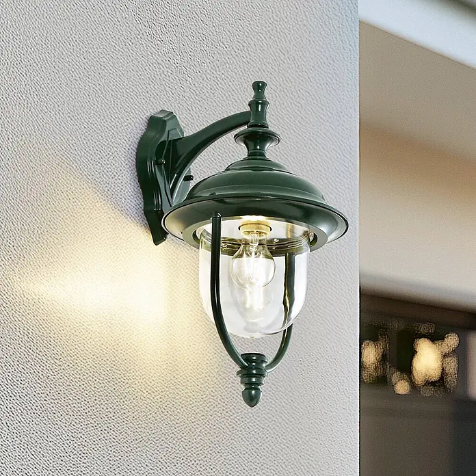 Lindby Außenwandleuchte Clint - grün, IP44 - Dunkelgrüne Wandlaterne mit klarem Glas und leuchtender Glühbirne, wirft warmes Licht.