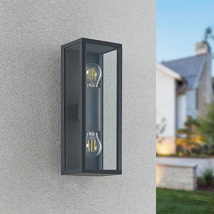 Lindby Außenwandleuchte Peldar - schwarz, IP44 - Dunkelgraue rechteckige Außenwandleuchte mit Klarglas und zwei Vintage-LED-Lampen an strukturierter Außenwand.