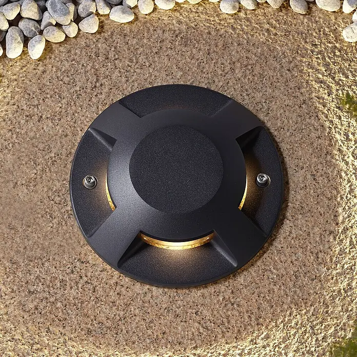 Lucande LED-Gartenstrahler Jeffrey - 3.000 K - Dunkelgraue runde Bodenleuchte in gepflastertem Untergrund, spendet warmes Licht.