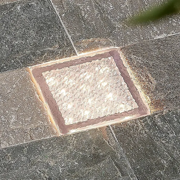 Prios LED-Gartenstrahler Ewgenie - 3.000 K, 10 x 10 x 6 cm - Quadratische Einbau-Bodenleuchte mit heller, strukturierter Oberfläche, eingelassen in dunkles Steinpflaster.