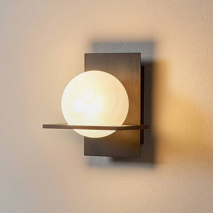 Lucande Wandleuchte Kulka - schwarz, G9 - Moderne Wandleuchte mit dunkler rechteckiger Halterung und weißem kugelförmigem Diffusor, beleuchtet an einer strukturierten Wand.
