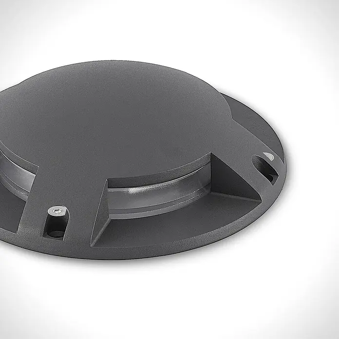 Lindby LED-Gartenstrahler Cormac - 3.000 K - Dunkelgraue runde Bodeneinbauleuchte mit texturierter Oberfläche und zentraler Klarabdeckung.