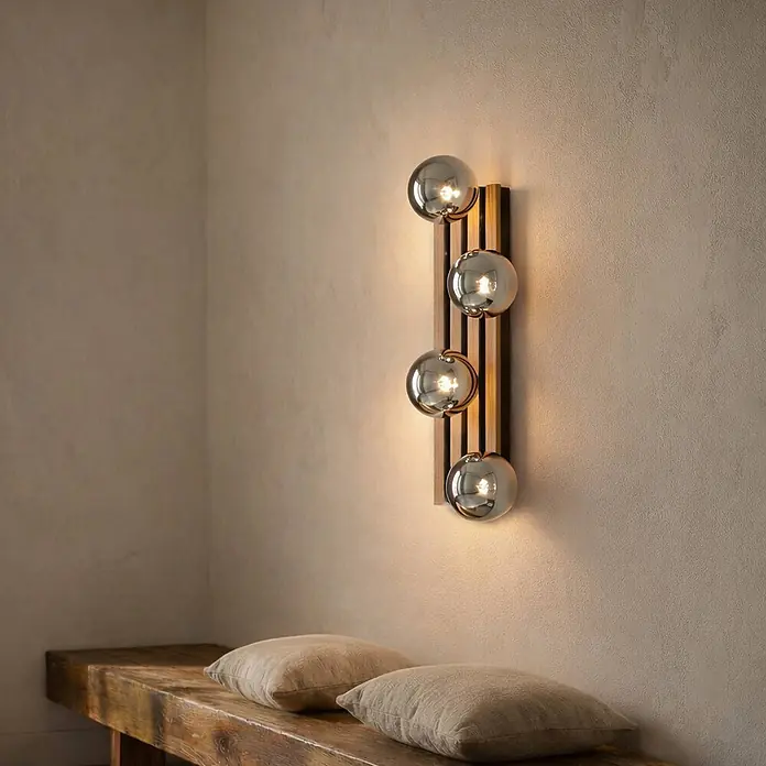 Lindby Wandleuchte Woodora - L x B x H: 16 x 68 x 19,5 cm, Holz hell, klar / transparent, G9 - Moderne Wandleuchte mit vier kugelförmigen Rauchglasleuchten auf Holzpaneel, beleuchtet Wand über Holzbank.