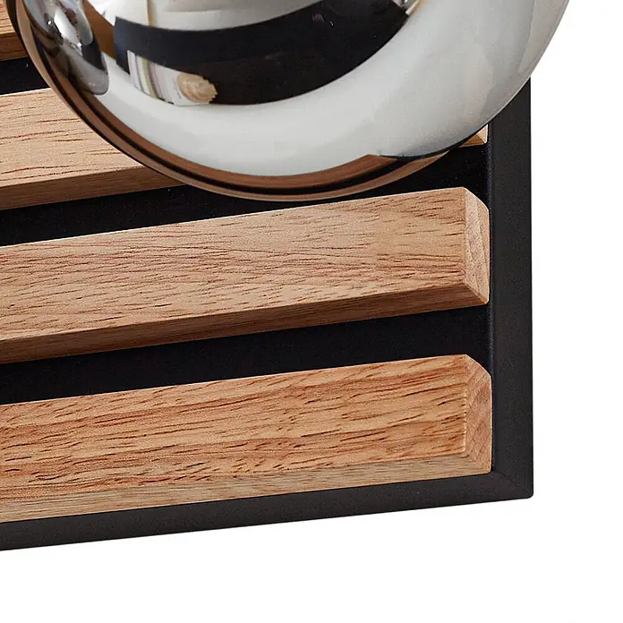 Lindby Wandleuchte Woodora - L x B x H: 16 x 68 x 19,5 cm, Holz hell, klar / transparent, G9 - Detail eines Weinregals mit hellen Holzleisten auf schwarzem Rahmen, das eine reflektierende Flasche hält.