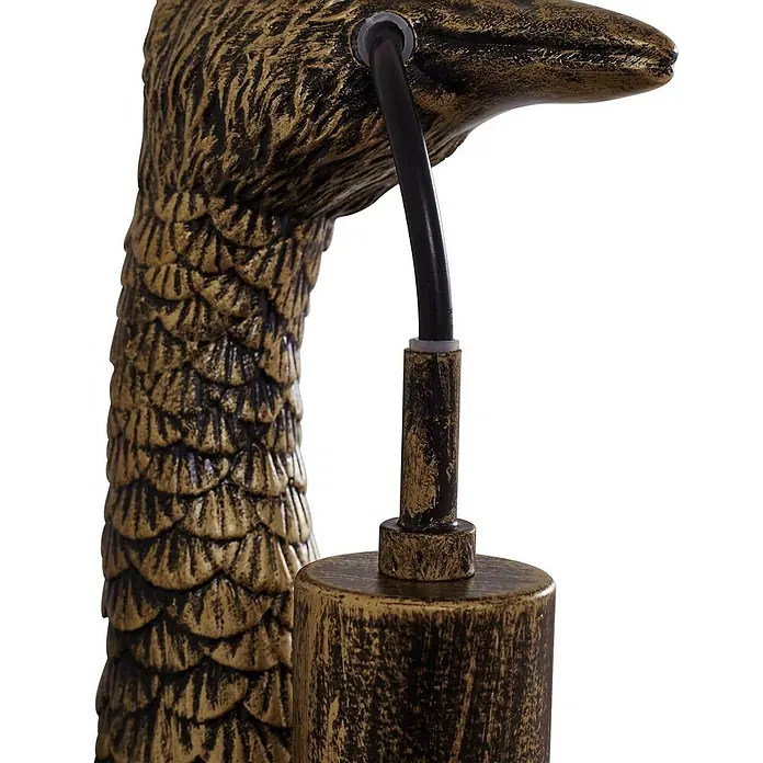 Lindby Wandleuchte Nirvathia - L x B x H: 24,5 x 9 x 30,5 cm, bronze / altmessing, E27 - Nahaufnahme eines altgoldfarbenen, texturierten Lampenbauteils mit schuppigen Details und schwarzem Kabel.
