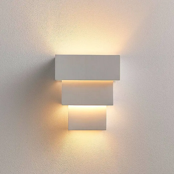 Lindby Wandleuchte Antonella - L x B x H: 10,5 x 18 x 21 cm, weiß / opal, G9 - Graue, mehrstufige Wandleuchte strahlt warmes Licht nach oben und unten auf eine strukturierte Wand.