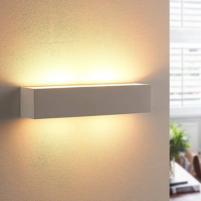 Lindby Wandleuchte Tjada - weiß / opal, G9 - Weiße rechteckige Wandleuchte mit warmer Up- und Downlight-Beleuchtung auf strukturierter Wand.