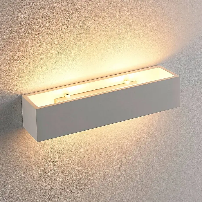 Lindby Wandleuchte Tjada - weiß / opal, G9 - Rechteckige weiße Wandleuchte, die warmes Licht nach oben und unten auf eine strukturierte Wand wirft.