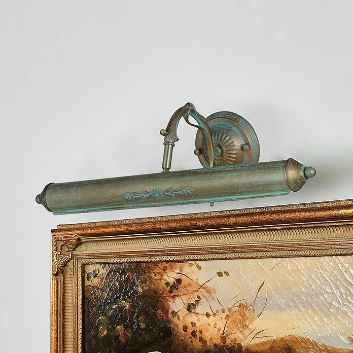 Lindby Wandleuchte Kalea - bronze / altmessing, bronze / altmessing, E14 - Antike Bilderleuchte aus Bronze mit Patina, beleuchtet ein gerahmtes Gemälde.