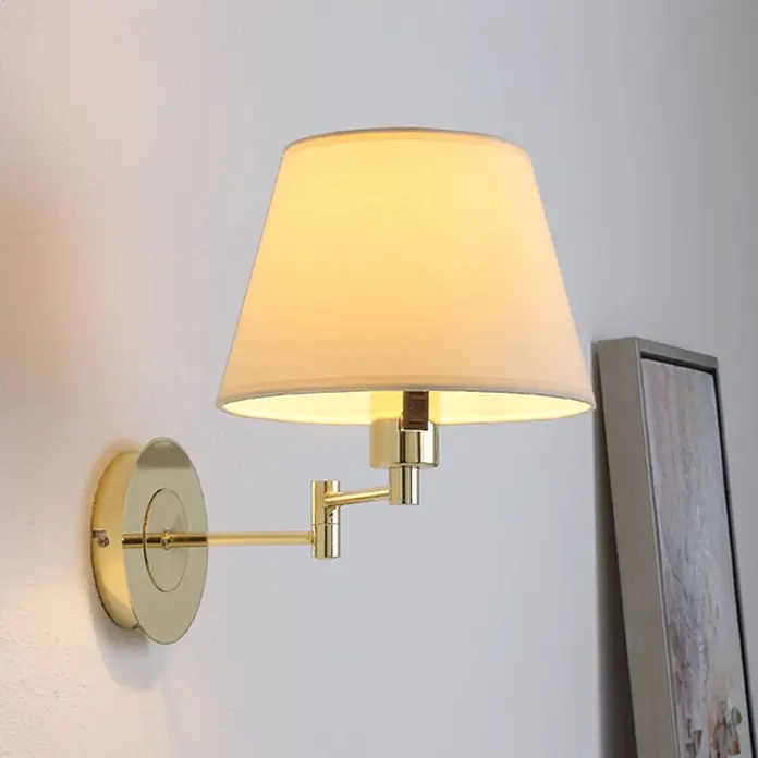 Lindby Wandleuchte Pola - messing / gold, creme / amber, E27 - Goldfarbene Schwenkarm-Wandleuchte mit beigefarbenem Stoffschirm, die warmes Licht abgibt.