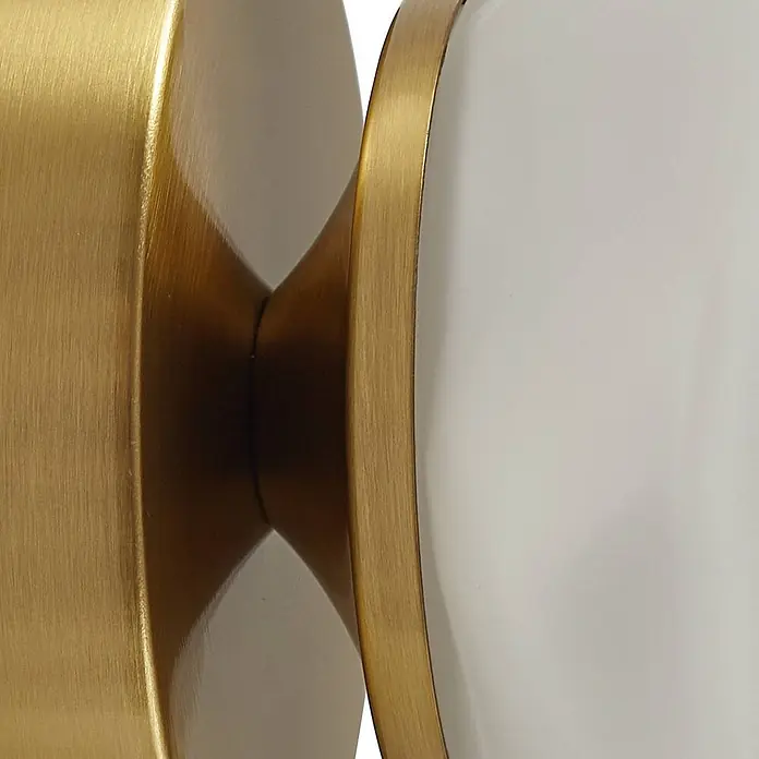 Lindby Wandleuchte Piatra - messing / gold, weiß / opal, G9 - Gebürsteter goldener Metallhocker in Sanduhrform mit weißer Oberfläche.