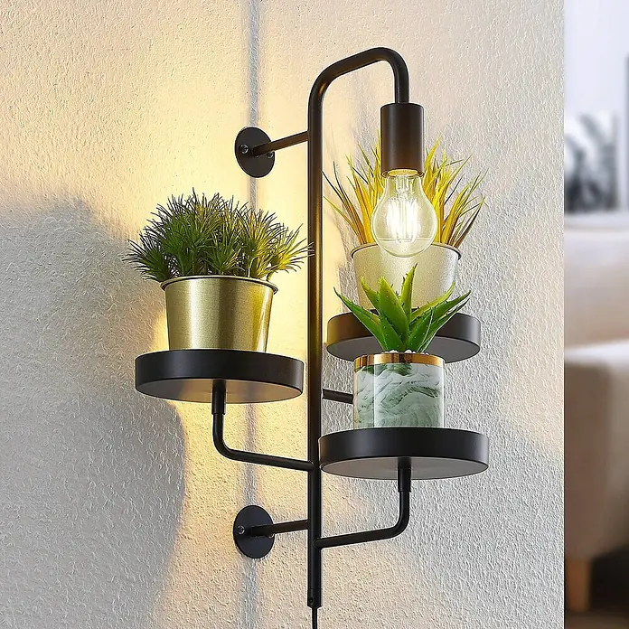 Lindby Wandleuchte Hanjo - schwarz, E27 - Schwarze Metall-Wandleuchte mit drei Regalen für Pflanzen und einer freiliegenden Glühbirne, an einer Wand montiert.