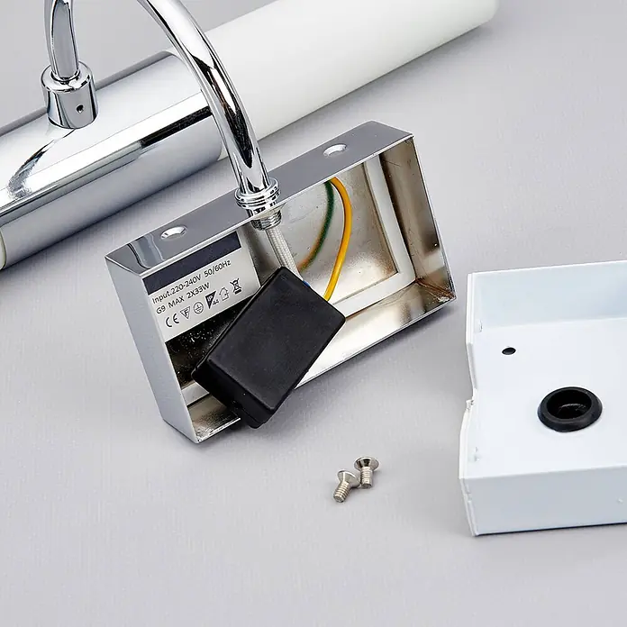Lindby Wandleuchte Devran - L x B x H: 17,1 x 35,5 x 13,5 cm, chrom / silber, G9 - Befestigungsbasis einer Chrom-Wandleuchte mit freiliegender Verdrahtung, schwarzem Bauteil und Schrauben.