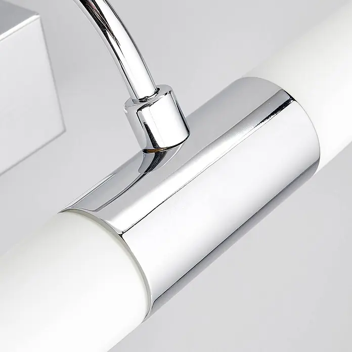 Lindby Wandleuchte Devran - L x B x H: 17,1 x 35,5 x 13,5 cm, chrom / silber, G9 - Nahaufnahme eines verchromten Arms, der an eine weiße zylindrische Leuchte anschließt.