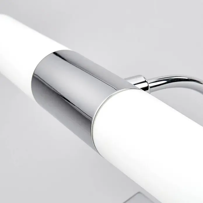 Lindby Wandleuchte Devran - L x B x H: 17,1 x 35,5 x 13,5 cm, chrom / silber, G9 - Nahaufnahme einer weißen zylindrischen Leuchte mit glänzendem Chromband und -arm.